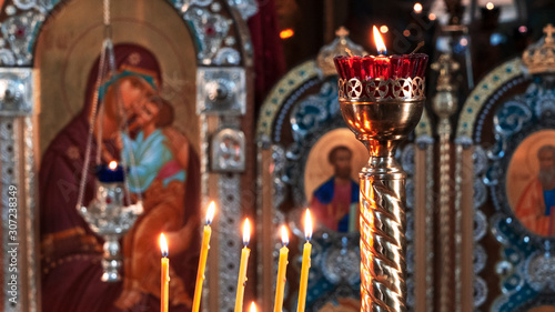 Obraz na plátně Wax burning candles in an orthodox church on the icon background.