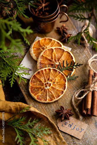 dried orange slices on wooden board with anise stars, cinnamon sticks