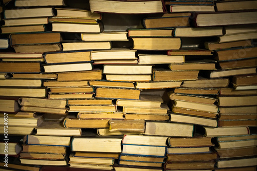 A huge pile of different books in the library. A library full of books. Reading. A huge number of books of different genres and sizes. Studying and education. Knowledge.