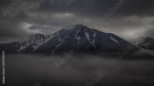 Clouds crowding in a snow covered mountain.  © Clearly Coastal 