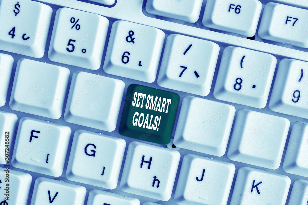 Handwriting text writing Set Smart Goals. Conceptual photo list to clarify your ideas focus efforts use time wisely White pc keyboard with empty note paper above white background key copy space Handwriting text writing Set Smart Goals. Conceptual photo list to clarify your ideas focus efforts use time wisely White pc keyboard with empty note paper above white background key copy space