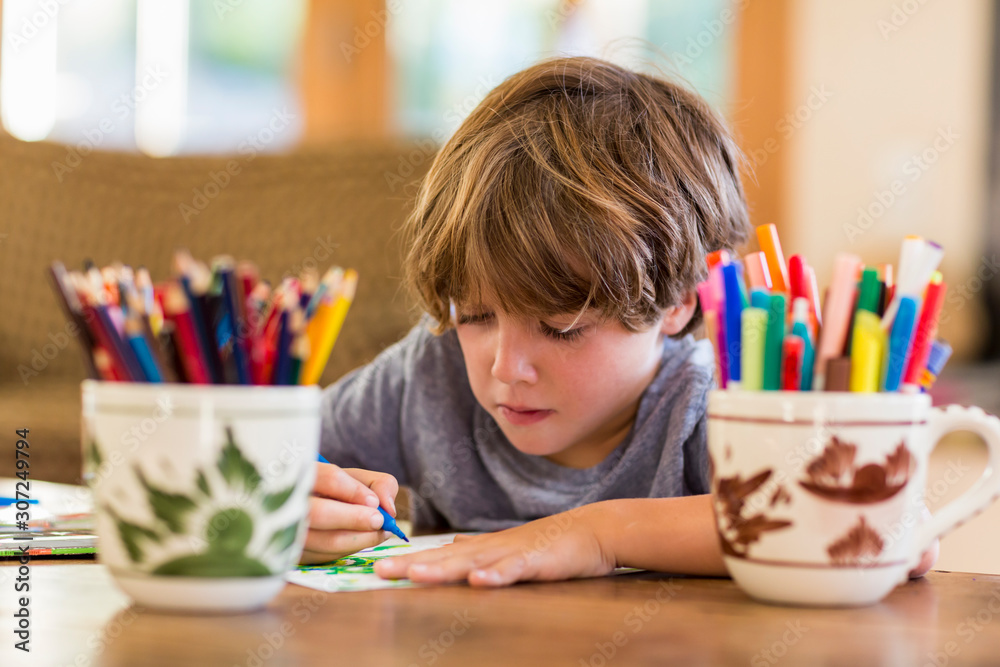 © Mint Images - 6 year old boy drawing amoung colorful pens © Mint Images - 6 year old boy drawing amoung colorful pens