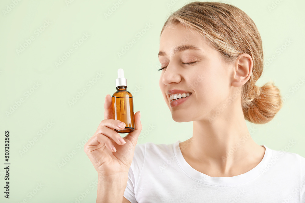Beautiful young woman with cosmetic product on light background Beautiful young woman with cosmetic product on light background
