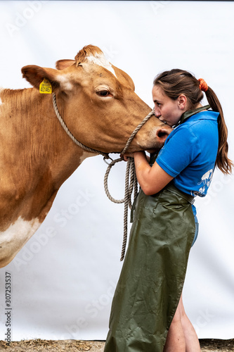 Young woman kissing Guernsey cow