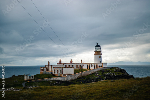 Close view to the nest point lighthouse located on isle of Skye in Scotland under cloudy sky