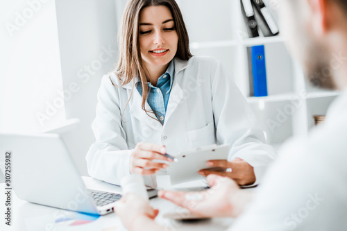 Doctor consulting patient. Patient sitting at doctor office. Diagnostic, prevention of diseases, healthcare, medical service, consultation or education.