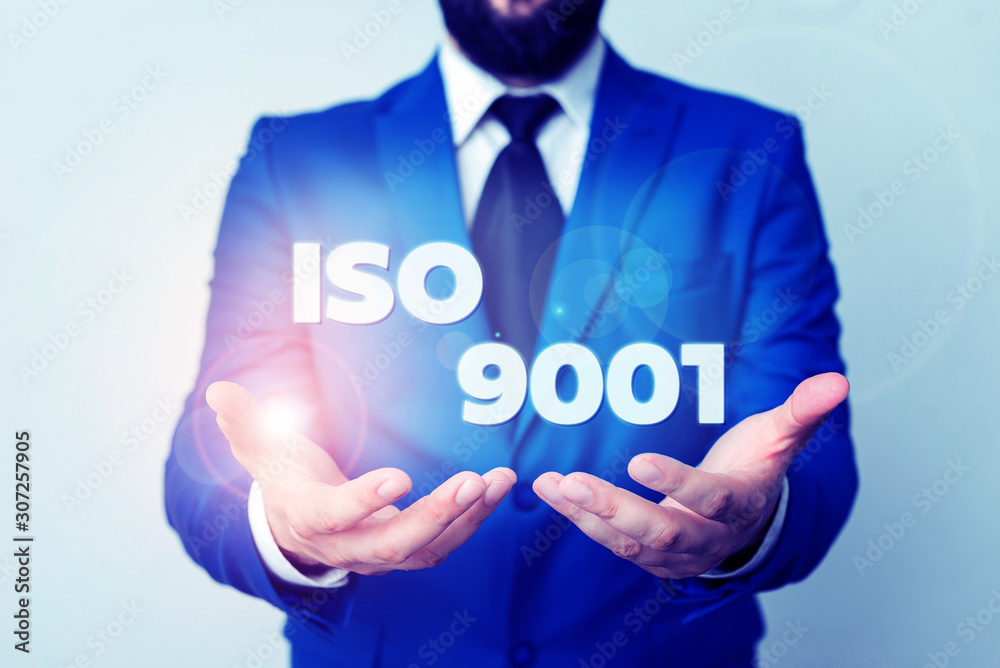 Text sign showing Iso 9001. Business photo showcasing designed help organizations to ensure meet the needs of customers Man with opened hands in fron of the table. Mobile phone and notes on the table Text sign showing Iso 9001. Business photo showcasing designed help organizations to ensure meet the needs of customers Man with opened hands in fron of the table. Mobile phone and notes on the table