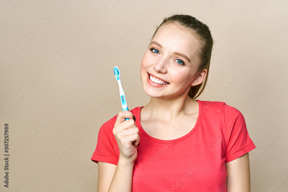 Young beautiful woman is engaged in cleaning teeth. Beautiful smile healthy white teeth. A girl holds a toothbrush. The concept of oral hygiene. Promotional image for a stomatology, dental clinic Young beautiful woman is engaged in cleaning teeth. Beautiful smile healthy white teeth. A girl holds a toothbrush. The concept of oral hygiene. Promotional image for a stomatology, dental clinic