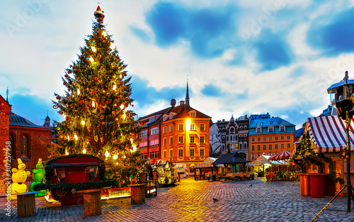 Tree at Night Christmas Market on Dome square in Winter Riga, Latvia. Advent Fair Decoration and Stalls with Crafts Items on the Bazaar. Latvian street Xmas and holiday