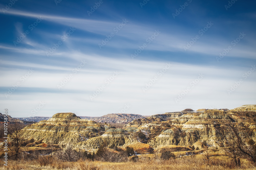 Multi layered colorful rock mountains in the Black Hills under a blue wispy sky in a springtime South Dakota landscape