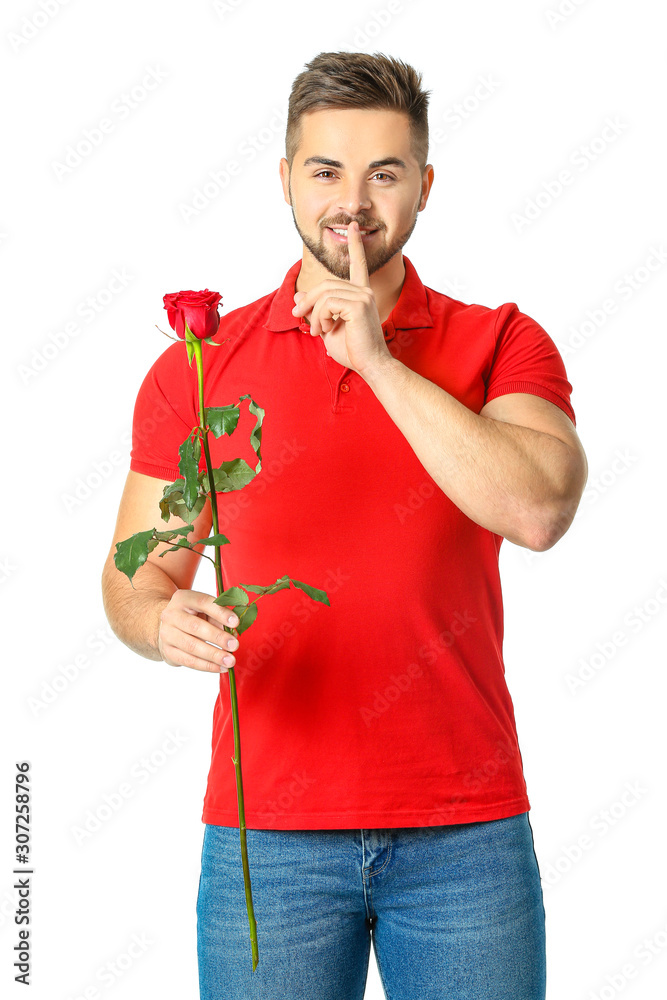 Handsome man with flower showing silence gesture on white background. Valentine's Day celebration Handsome man with flower showing silence gesture on white background. Valentine's Day celebration