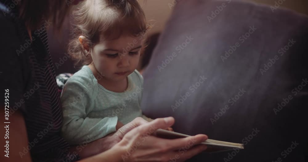 Cute toddler reading with her mom. Shot in 4K RAW on a cinema camera. Cute toddler reading with her mom. Shot in 4K RAW on a cinema camera.