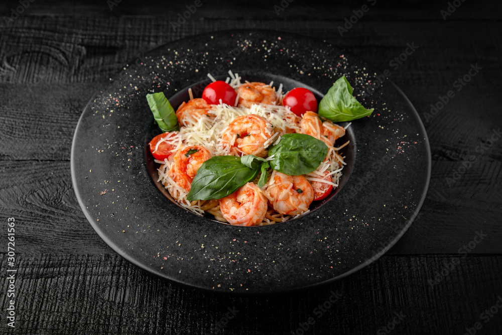 Spaghetti salad or pasta with shrimp, cherry tomatoes, cheddar cheese, parmesan, basil and sauce. Nutritious, dietary, fitness food. Black boards background Spaghetti salad or pasta with shrimp, cherry tomatoes, cheddar cheese, parmesan, basil and sauce. Nutritious, dietary, fitness food. Black boards background