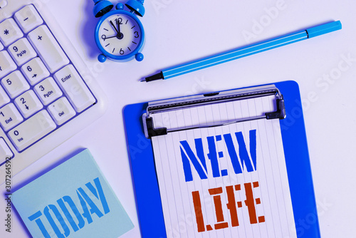 Writing note showing New Life. Business concept for start of change in the existence of an individual or animal Flat lay above table with clock pc keyboard and copy space note paper photo