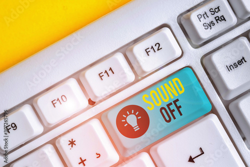 Conceptual hand writing showing Sound Off. Concept meaning To not hear any kind of sensation produced by stimulation White pc keyboard with note paper above the white background photo