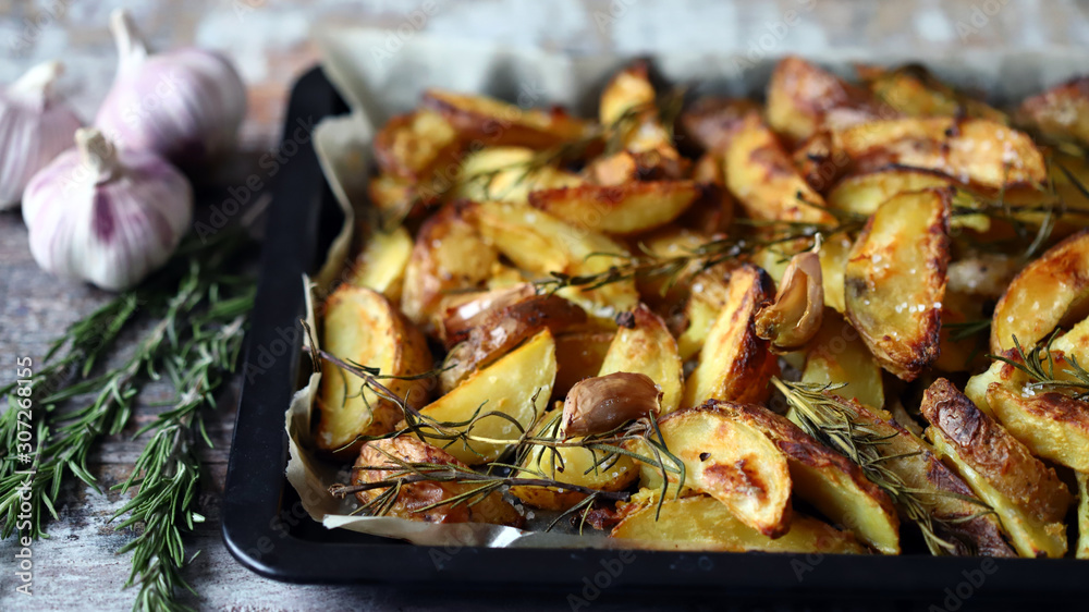 Selective focus. Homemade baked rustic potato with garlic and rosemary. Selective focus. Homemade baked rustic potato with garlic and rosemary.