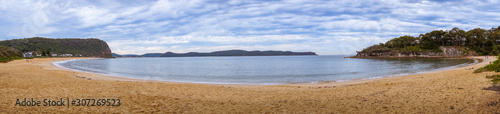 Panorama of tropical lagoon with sandy beach and mountains in the distance