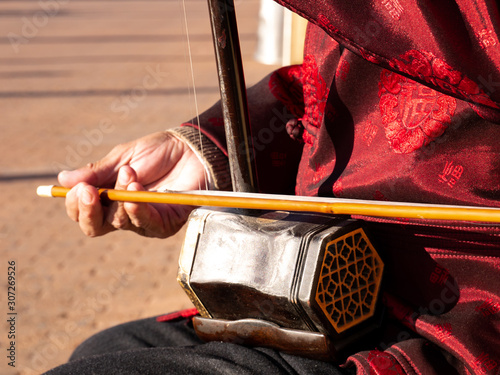Asian senior man playing an erhu in the street photo