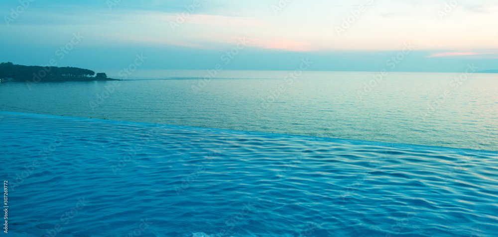 Obraz premium Swimming Pool with sunset on the sea