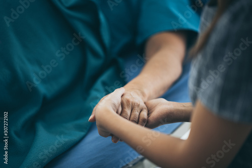 Doctor or nurse holding elderly lady s hands.