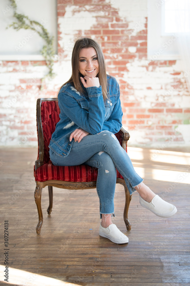 Stunning young brunette woman wearing denim jacket, black turtleneck and blue  jeans poses in studio foto de Stock | Adobe Stock