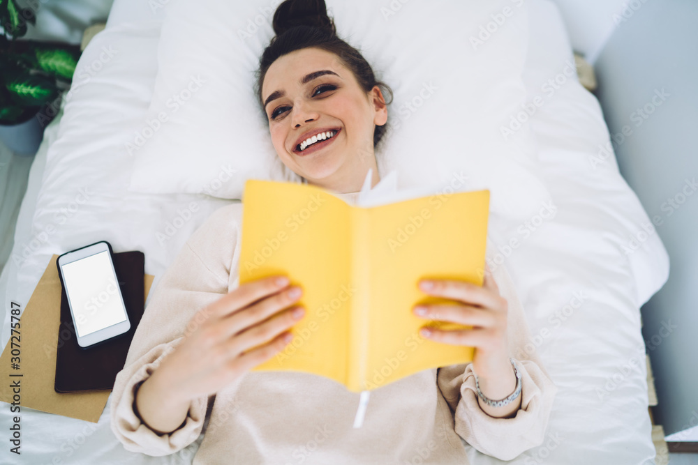 Woman with book resting in bed Woman with book resting in bed