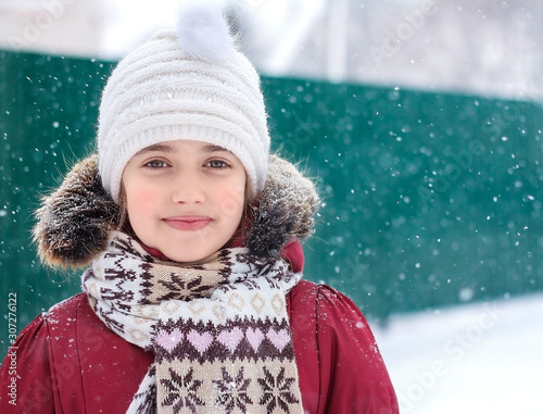 winter portrait of a child in a white hat.