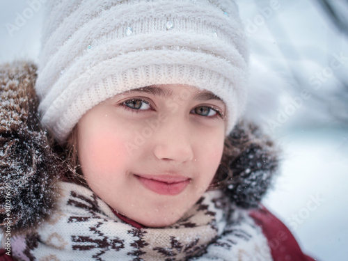 winter portrait of a child in a white hat.