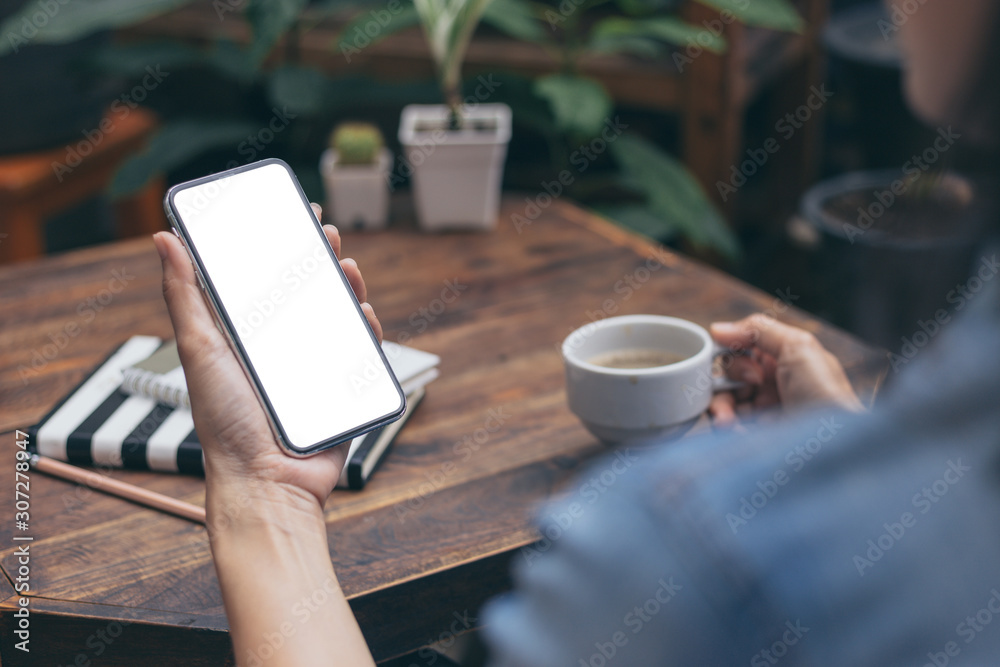 Mockup image blank white screen cell phone.men hand holding texting using mobile on desk at coffee shop.background empty space for advertise text.people contact marketing business and technology Mockup image blank white screen cell phone.men hand holding texting using mobile on desk at coffee shop.background empty space for advertise text.people contact marketing business and technology