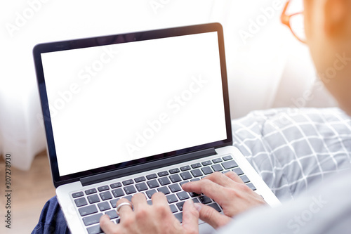 mockup image blank screen computer with blank white background for advertising text,hand man using laptop contact business search information on desk at home office.marketing and creative design