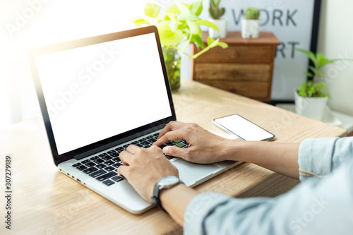 mockup image blank screen computer,cell phone with white background for advertising text,hand man using laptop texting mobile contact business search information on desk in office.marketing and design