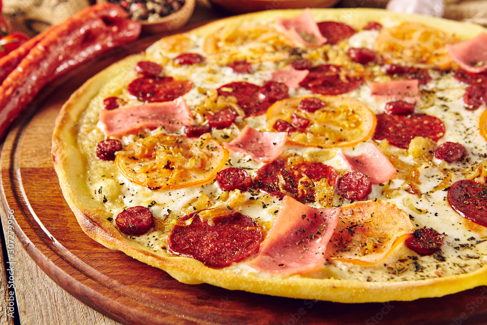 Meat and tomato pizza on wooden table close up Meat and tomato pizza on wooden table close up