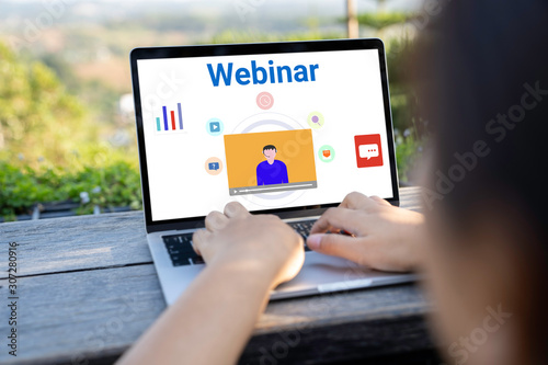 Person using a laptop computer for online training webinars. E-learning browsing connection and cloud online technology webcast concept. Laptop mockup with clipping path on screen.