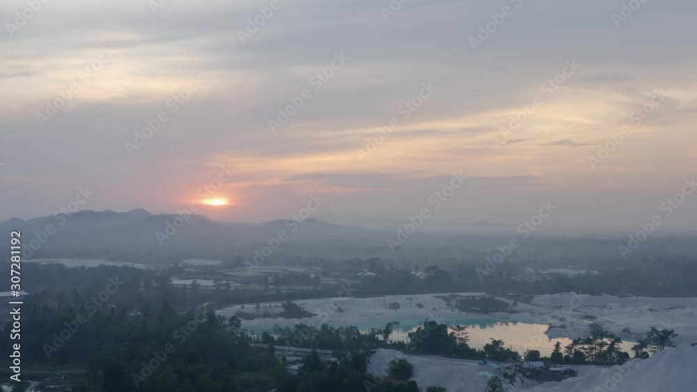 Aerial dolly out view of Kaolin Lake mine pit area cloudy sky at sunrise Belitung island, Bangka Indonesia, reveal shot Aerial dolly out view of Kaolin Lake mine pit area cloudy sky at sunrise Belitung island, Bangka Indonesia, reveal shot