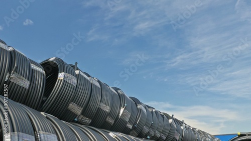 Warehouse of finished plastic pipes industrial outdoors storage site. Manufacture of plastic water pipes factory. Process of making plastic tubes on the machine tool with the use of water and air