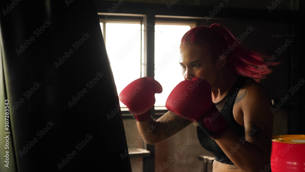 Asian woman doing boxing in the gym.