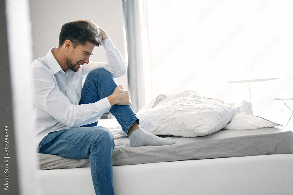 man sitting on sofa and working on laptop