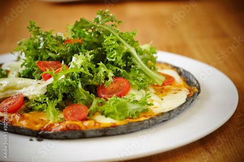 Black dough salad pizza with black pepper 
