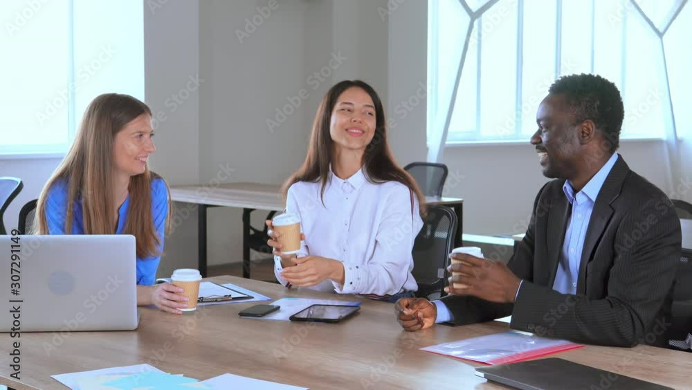 business people have coffee break in office in start up company sitting at the workplace have lunch talking laughing