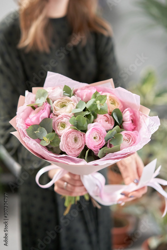 Wallpaper Mural Persian buttercup in womans hands. Bunch pale pink ranunculus flowers with green eucalyptus. The work of the florist at a flower shop Torontodigital.ca