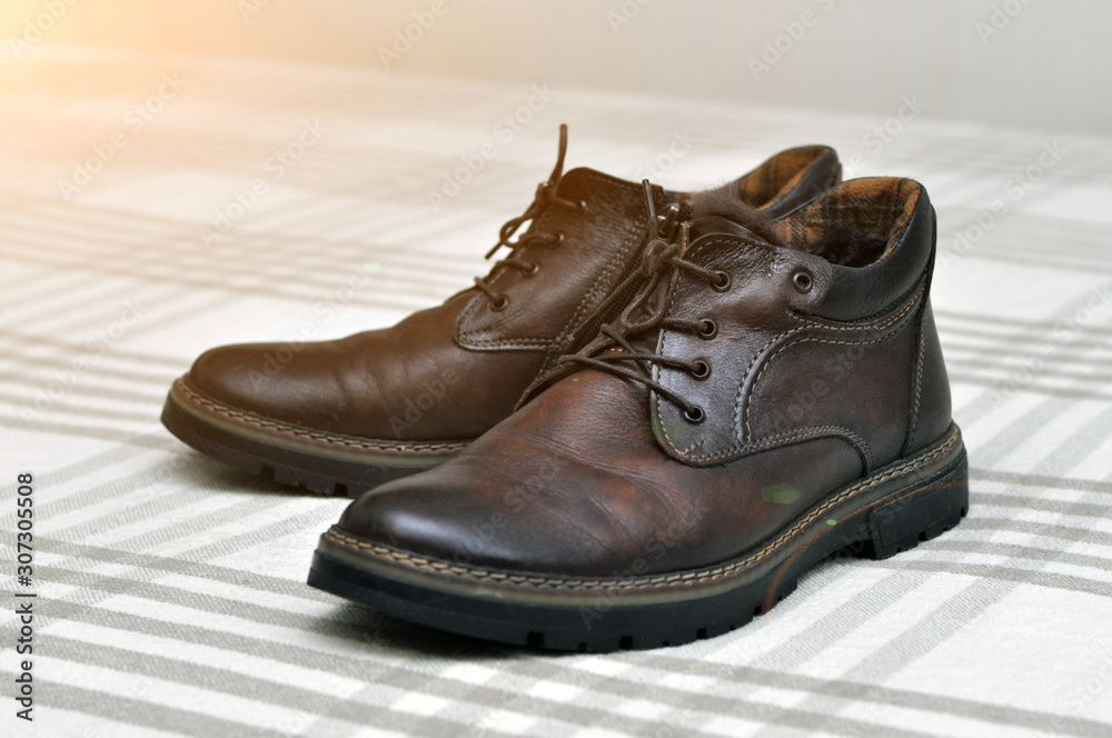 Men's insulated brown shoes made of genuine leather and with fur with lacing.
