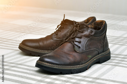 Men s insulated brown shoes made of genuine leather and with fur with lacing.