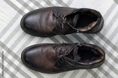 Men's insulated brown shoes made of genuine leather and with fur with lacing.