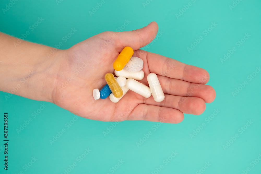 many tablets in a child's hand should be taken on blue background many tablets in a child's hand should be taken on blue background
