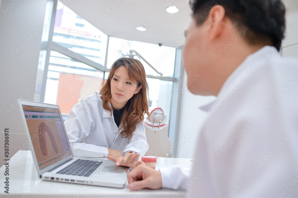 2 dentists discussing medical patient case with laptop 2 dentists discussing medical patient case with laptop