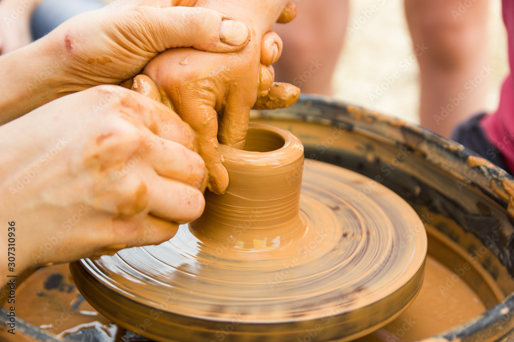 A close up view on ceramic production process on potter's wheel with children. Clay crafts with kids concept. A close up view on ceramic production process on potter's wheel with children. Clay crafts with kids concept.