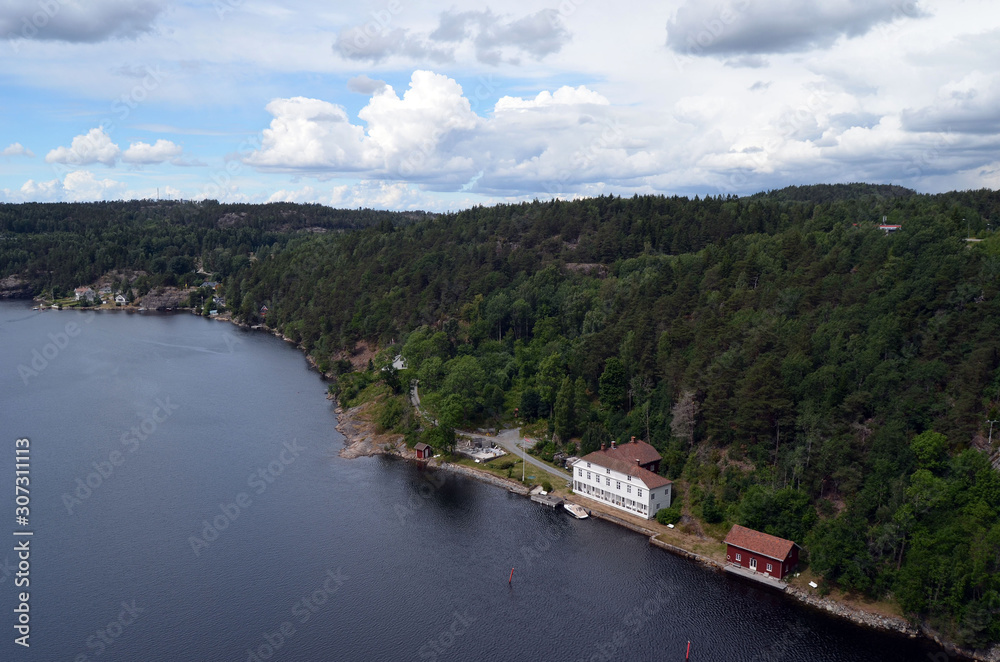 Typical Swedish nature and houses on the shore of the fjord. View from the high bridge over the fjord. The border of Norway and Sweden.Near the town Selater,Sweden