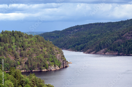 Typical Swedish nature and houses on the shore of the fjord. View from the high bridge over the fjord. The border of Norway and Sweden.Near the town Selater,Sweden