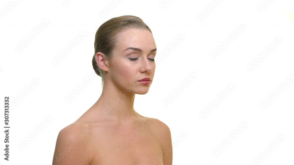 Young beautiful naked model in the studio looking seriousely to camera, on a white background. For cosmetics, caring for health and hygiene Young beautiful naked model in the studio looking seriousely to camera, on a white background. For cosmetics, caring for health and hygiene