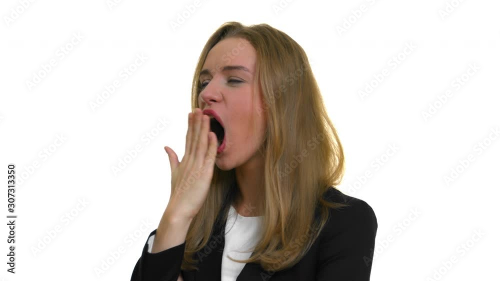 A bored business woman ostentatiously yawns to show her weariness. White studio background. A bored business woman ostentatiously yawns to show her weariness. White studio background.